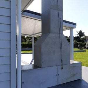 Backview of an outdoor fireplace on a beautiful backyard