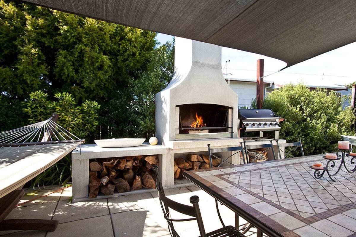 A beautiful backyard dining area with a stunning Flare Senator Outdoor Fire