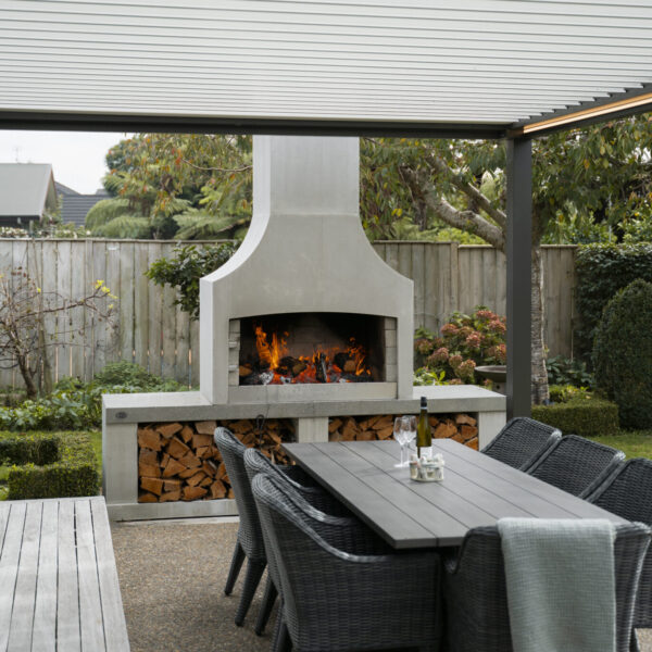Outdoor fireplace beside a dining table, with clear working space in front of the firebox