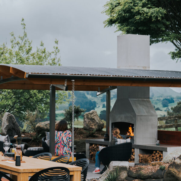 Outdoor fireplace built in under a lean-to roof, with the chimney taken up through the ceiling